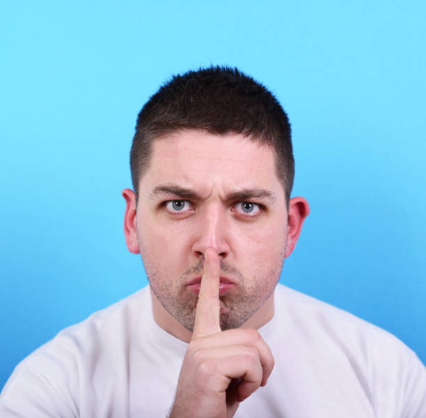 istock Portrait of man making silence gesture 656711296