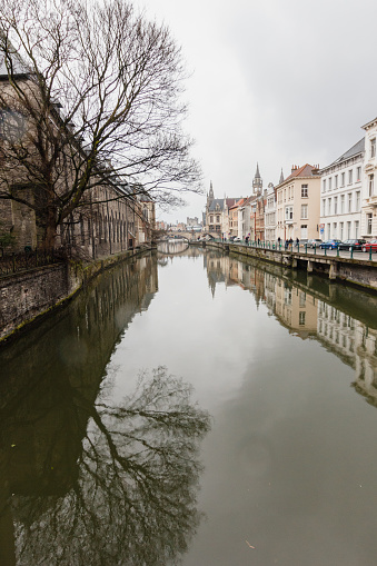 Canals and architecture of streets of Ghent town, Belgium in rainy day in winter