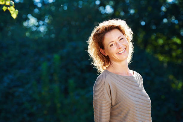 istock Happy older woman standing in tranquil park 656711706