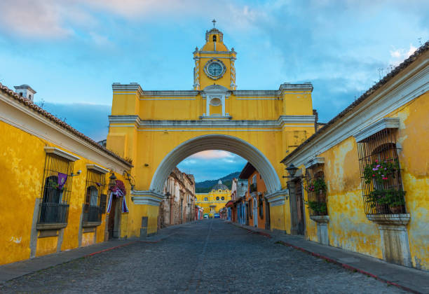Antigua Arch The main street of Antigua city with the yellow Santa Catalina arch at sunrise, Guatemala. agua volcano photos stock pictures, royalty-free photos & images