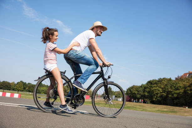 istock Happy man riding bicycle with daughter 656737216