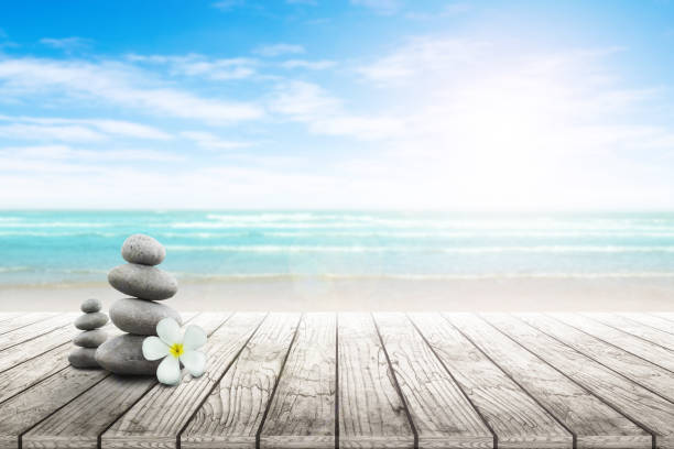 istock Stack of pebble stones and Plumeria wooden surface. 656750612