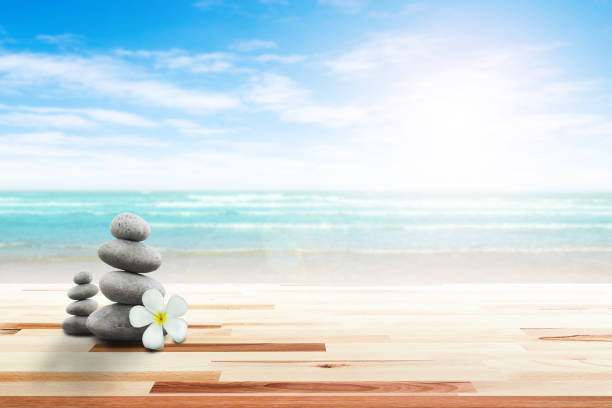 istock Stack of pebble stones and Plumeria wooden surface. 656750644