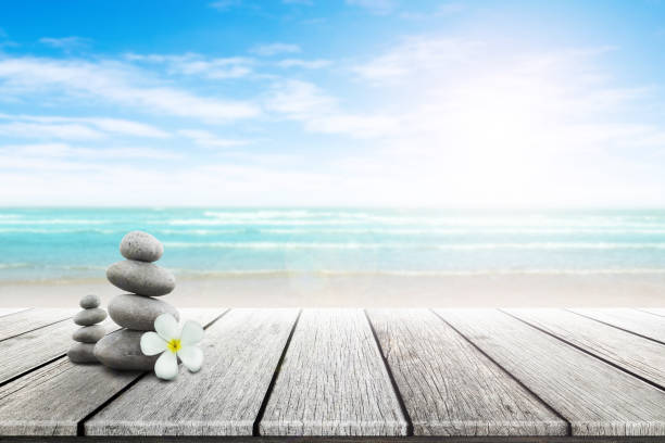 istock Stack of pebble stones and Plumeria wooden surface. 656750674