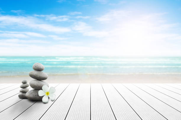 istock Stack of pebble stones and Plumeria wooden surface. 656750856