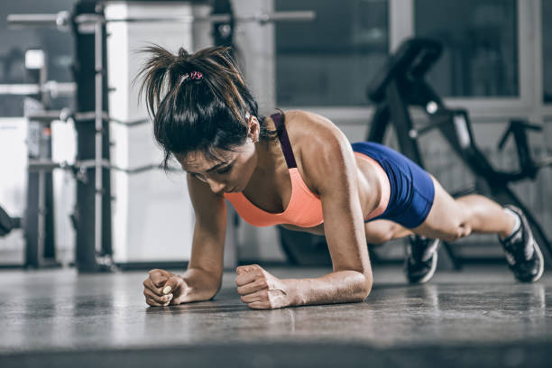 sport. femme musclée sur une position de planche. - muscular build wellbeing exercise equipment instructor photos et images de collection