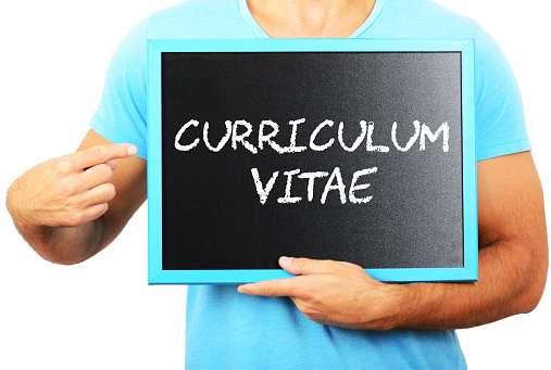 Man holding blackboard in hands and pointing the word CURRICULUM VITAE