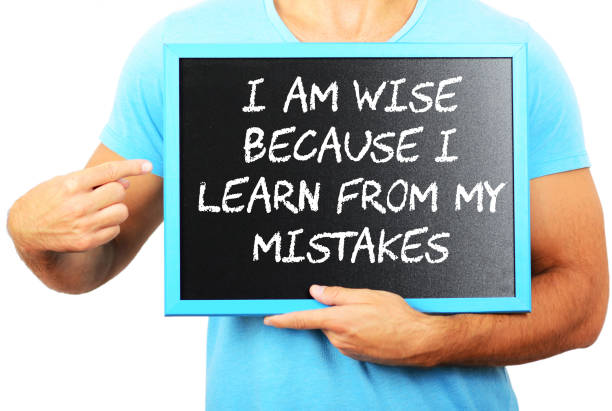 istock Man holding blackboard in hands and pointing the word I AM WISE BECAUSE I LEARN FROM MY MISTAKES 656751908