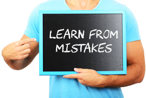istock Man holding blackboard in hands and pointing the word LEARN FROM MISTAKES 656751950