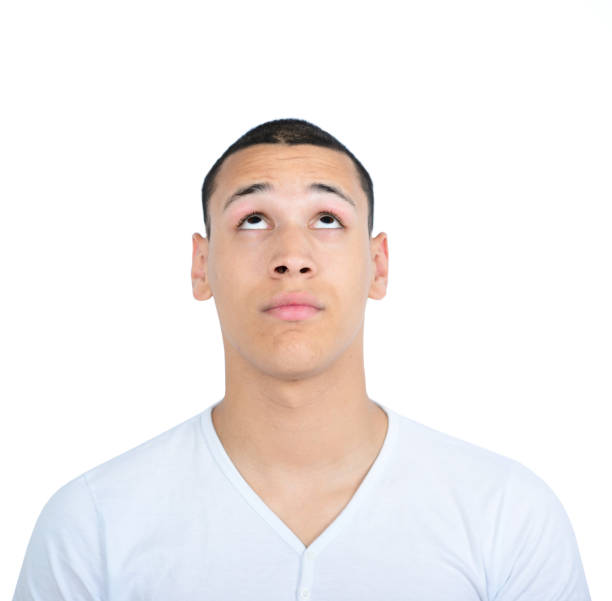 istock Portrait of young man looking up against white background 656752490