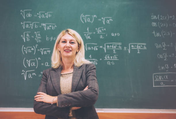 istock Senior math professor in lecture hall near the blackboard with formulas 656759076