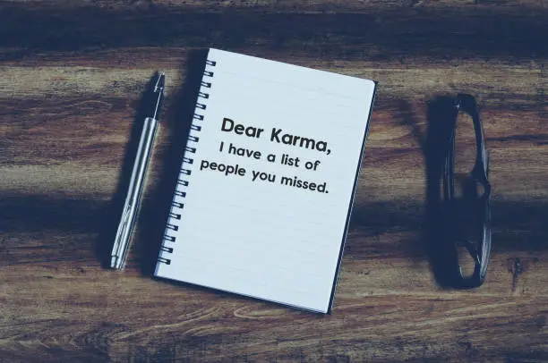 Funny inspirational quotes with phrase "dear Karma, i have a list of people you missed" on notepad with vintage background.