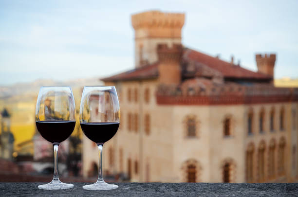 Red wine chalices with the castle of Barolo Two glasses of Barolo wine on a windowsill with the castle of Barolo (Piedmont, Italy) blurred on the background cuneo stock pictures, royalty-free photos & images