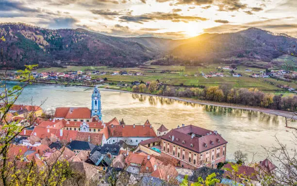 Panoramic aerial view of beautiful Wachau Valley with the historic town of Durnstein and famous Danube river in beautiful golden evening light at sunset, Lower Austria region, Austria