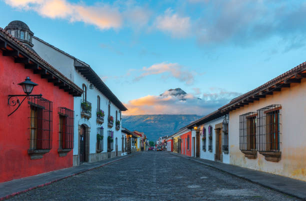 Antigua Sunrise Sunrise in the main street of Antigua with its colorful Spanish colonial historic center and the Agua volcano in the background, Guatemala. agua volcano photos stock pictures, royalty-free photos & images