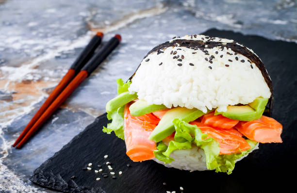 Homemade asian style gluten free sushi salmon burger. Sushi-food hybrids trend. Bright blue background with copy space stock photo