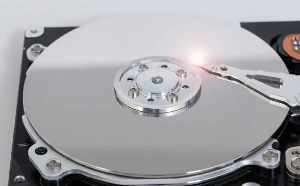 Photo of Open hard drive with magnetic disk and writing head