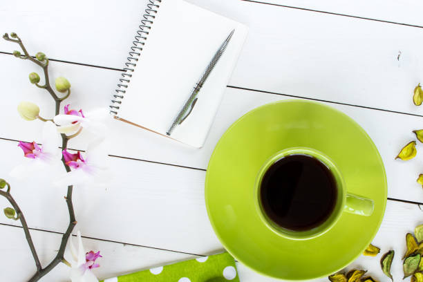 istock tea in green cup, notebook and silver pen, dry flower decor 656783628