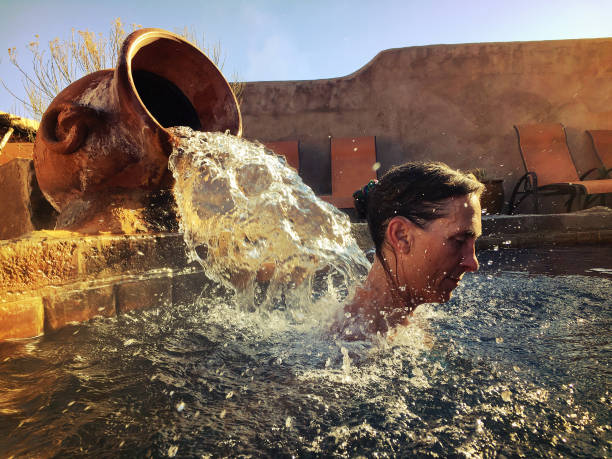 Woman in a hot pool enjoying water on her neck. Northern New Mexico, American Southwest.
