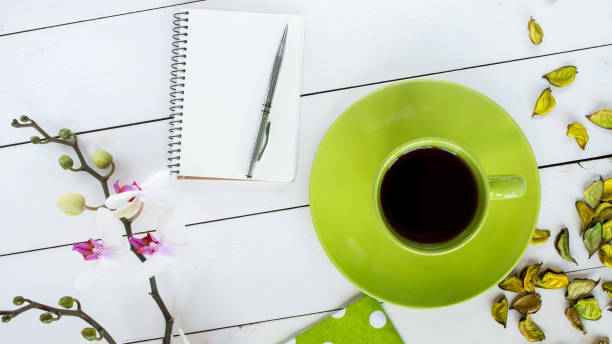 istock tea in green cup, notebook and silver pen, dry flower decor 656786892