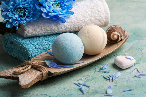 SPA treatment. Blue flowers and bath bombs on concrete background.
