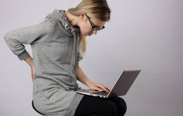 istock Bad posture effects.Female student using laptop and suffering from back pain 656790294