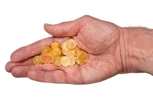 Pure gold tenth ounce coins in senior man hand Senior man's hand holding tenth ounce pure gold USA treasury coins and isolated against a white background golden nest egg taxes stock pictures, royalty-free photos & images