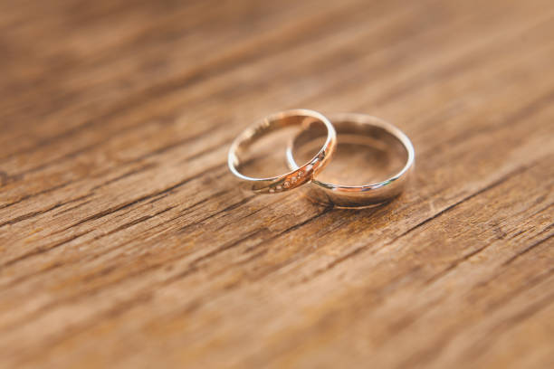 istock two gold wedding rings on a wooden background, macro, DOF 656793320