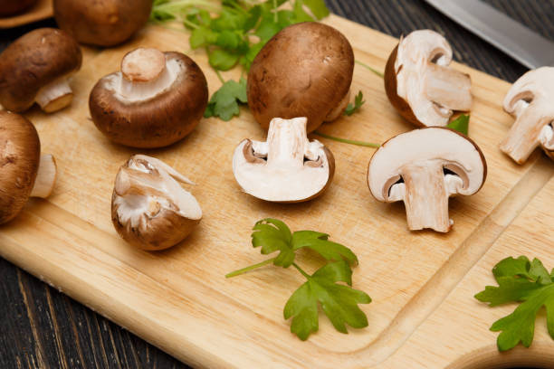 istock Raw royal champignons with green leaves on rustic board. 656795488