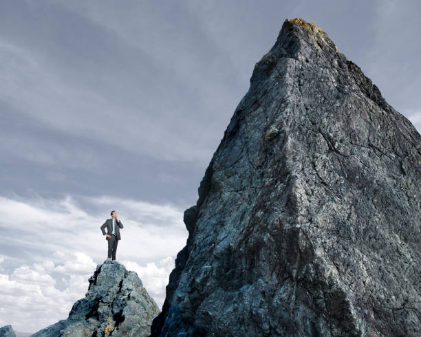 istock Businessman Looking Up At Tall Mountain 656799984