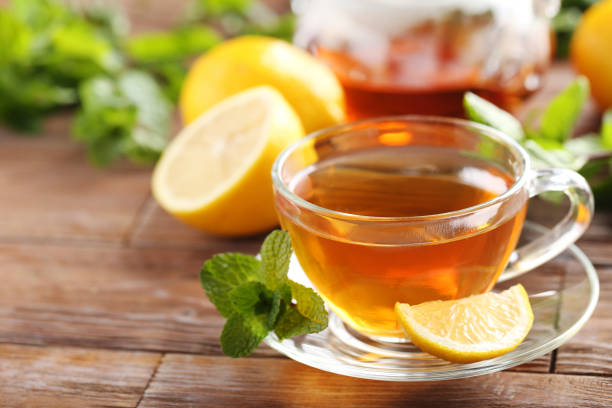 istock Cup of tea with mint and lemon on brown wooden table 656807118
