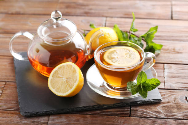 istock Cup of tea with mint and lemon on brown wooden table 656807432