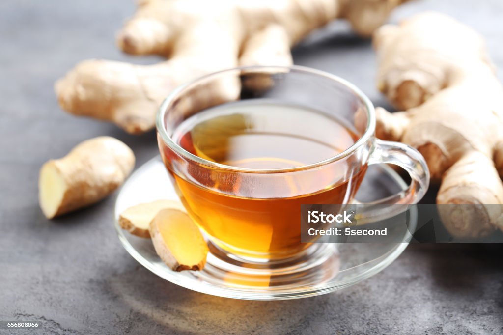 Cup of tea with ginger root on grey wooden table Ginger - Spice Stock Photo