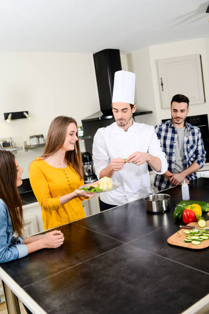 istock professional personal chef cook in customer's private kitchen house giving a cooking lesson to young people at home 656811148