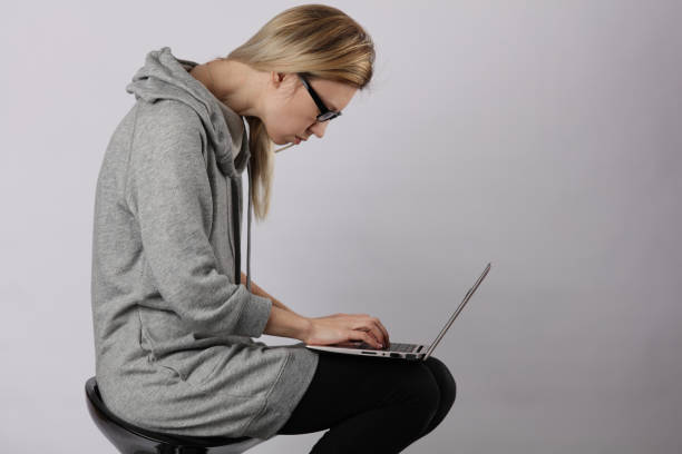 Bad posture effects.Female student using laptop and suffering from back pain