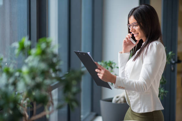 istock Businesswoman looking at documents and talking on phone 656838460