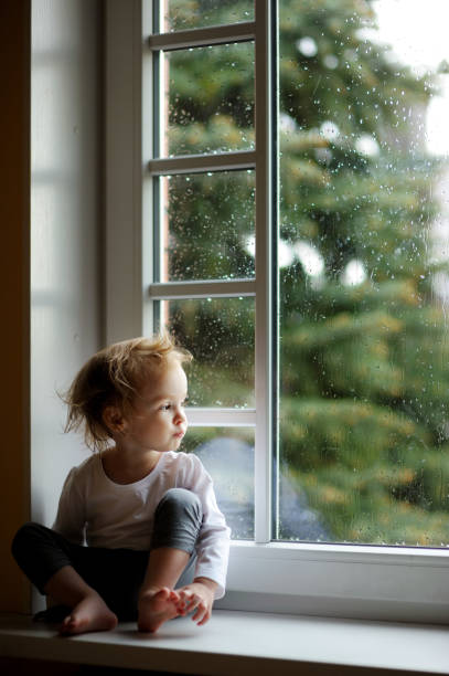 istock Adorable toddler girl looking though the window 656849038