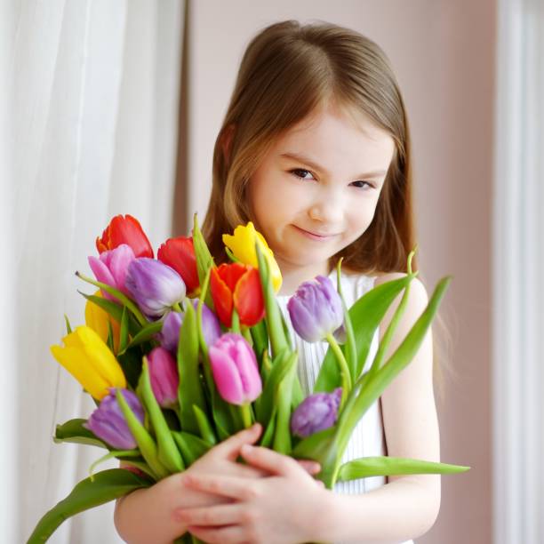 istock Adorable smiling little girl with tulips 656849094