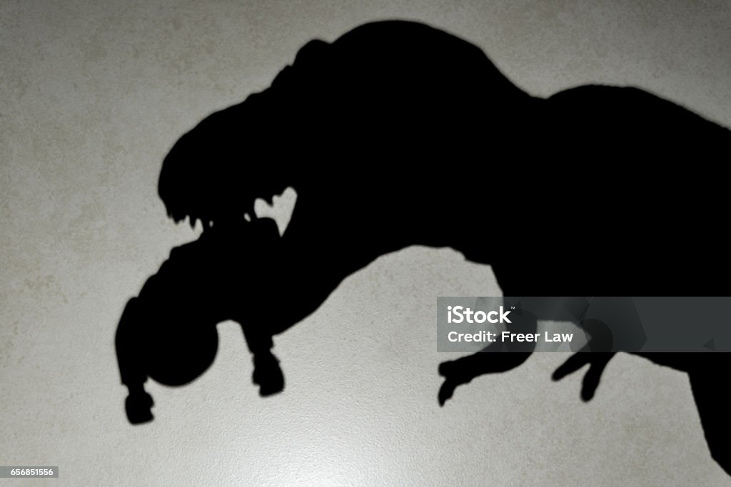 sombra de tiranosaurio mordiendo un cuerpo en la pared - Foto de stock de Animal libre de derechos