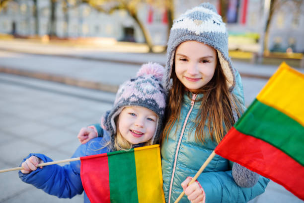 istock Two adorable little sisters holding Lithuanian flags in Vilnius 656854608