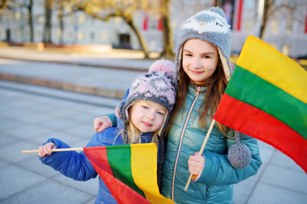 istock Two adorable little sisters holding Lithuanian flags in Vilnius 656854626