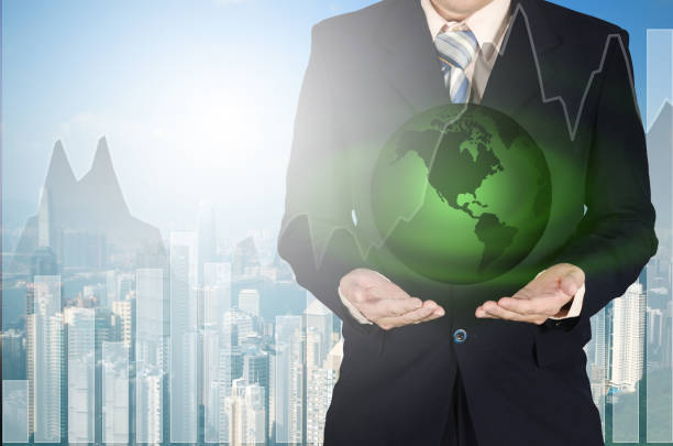 istock Young businessman holding green earth planet in hand standing with growth graph chart on blurred city building background. Elements of this image are furnished by NASA 656864526