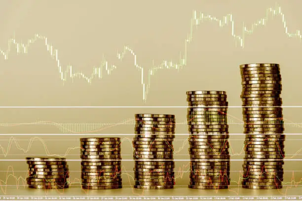Double exposure of financial graph chart and rows of coins for finance and business concept, shallow focus