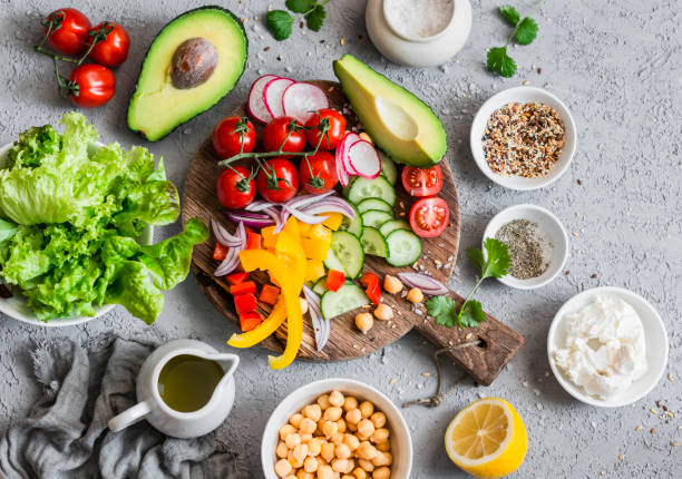 ingredients for spring vegetable buddha bowl. delicious healthy food.  on a gray background, top view - arugula salad herb organic imagens e fotografias de stock