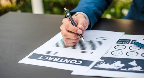 istock Handsome businessman wearing suit and using modern laptop outdoors and graph finance diagram. 656885382