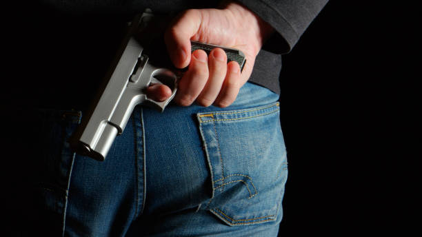 istock Danger man with a pistol behind the back 656886238
