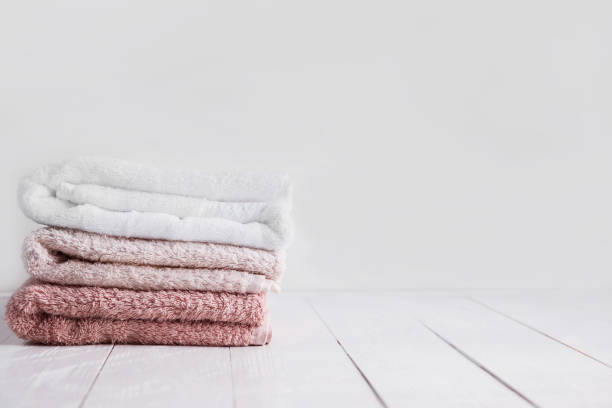istock Stack of clean towels on wooden table in bathroom. 656889512