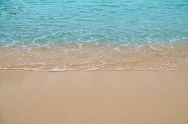Soft wave of blue ocean on sandy beach. Background.