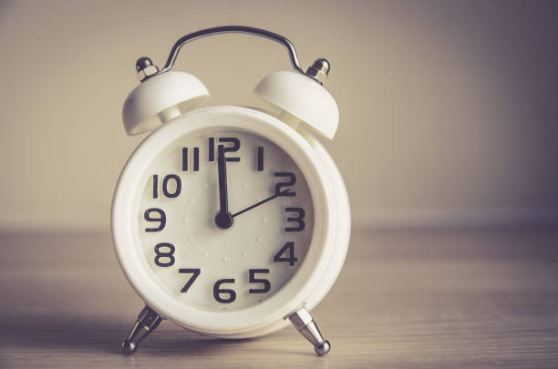 istock Retro alarm clock on a table. Photo in retro color image style 656899598