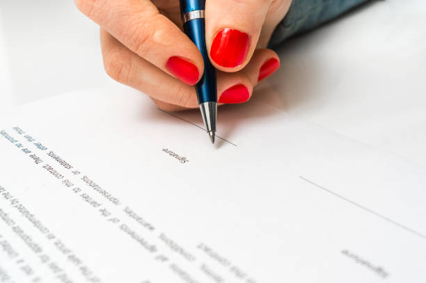 istock Woman with ballpoint pen signing contract document 656909158